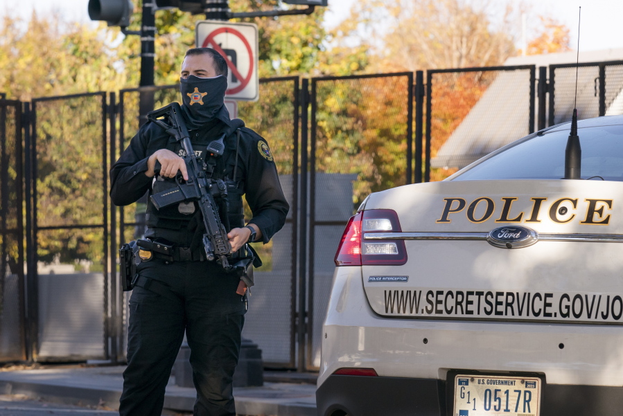 FILE - A U.S. Secret Service officer takes a position in the street as President Donald Trump's motorcade arrives at the White House after golfing at his Trump National Golf Club in Sterling, Va., in Washington, Nov. 8, 2020, a day after was defeated by President-elect Joe Biden. A government watchdog has found that Secret Service agents deleted text messages sent and received around the Jan. 6, 2021, attack on the U.S. Capitol after an inspector general requested them as part of the investigation into the insurrection. (AP Photo/J.