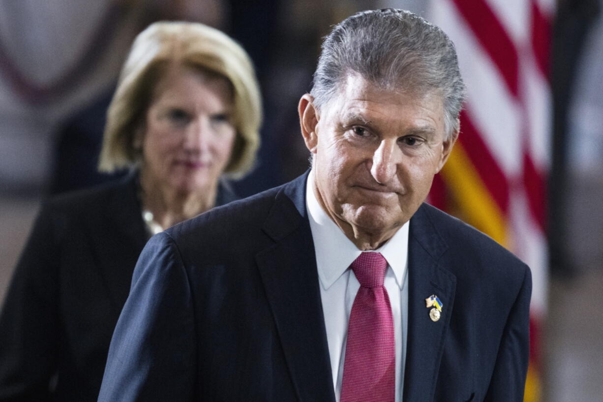 Sen. Joe Manchin, D-W.Va., and Sen. Shelley Moore Capito, R-W.Va., pay their respects as the flag-draped casket bearing the remains of Hershel W. "Woody" Williams, lies in honor in the U.S. Capitol, Thursday, July 14, 2022 in Washington. Manchin has told Senate Majority Leader Chuck Schumer that he will oppose a economic measure if it includes climate or energy provisions or boosts taxes on the rich or corporations.