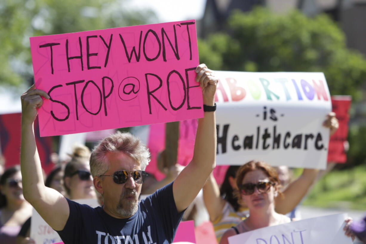 FILE - A man holds a sign as community members walk around Vander Veer Park during a march following the Supreme Court decision to overturn Roe v. Wade, June 26, 2022, in Davenport, Iowa. Democrats and their aligned groups raised more than $80 million in the week after the Supreme Court stripped away a woman's constitutional right to have an abortion. The flood of cash offers one of the first tangible signs of how the ruling may energize voters.