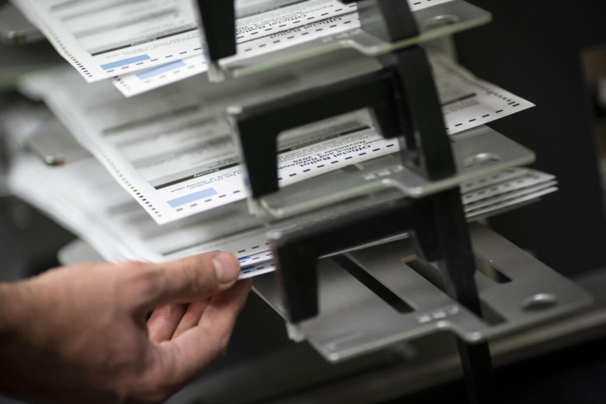 FILE - Poll workers sort out early and absentee ballots at the Kenosha Municipal building on Election Day, Nov. 3, 2020, in Kenosha, Wis.  Wisconsin's conservative-controlled Supreme Court ruled Friday, July 8, 2022, that absentee ballot drop boxes may be placed only in election offices and that no one other than the voter can return a ballot in person, dealing a critical defeat to Democrats in the battleground state.