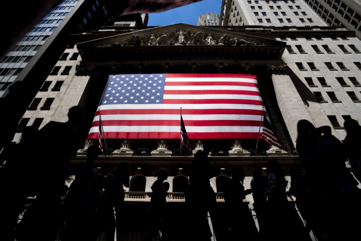 People walk past the New York Stock Exchange on Wednesday, June 29, 2022 in New York.  Stocks are opening lower across the board on Wall Street, Tuesday, July 5,  and crude oil prices are dropping again.