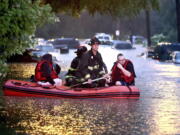 Steven Bertke and his dog Roscoe are taken to dry land by St. Louis firefighters who used a boat to rescue people from their flooded homes on Hermitage Avenue in St. Louis on Tuesday, July 26, 2022. (David Carson/St.