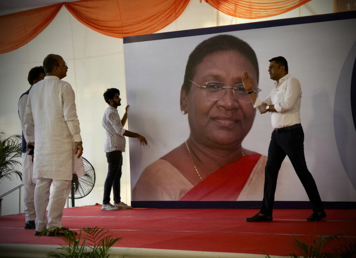 Workers put up a giant hoarding of Draupadi Murmu for her felicitation, before she was announced as the country's new President, in New Delhi, India, Thursday, July 21, 2022.