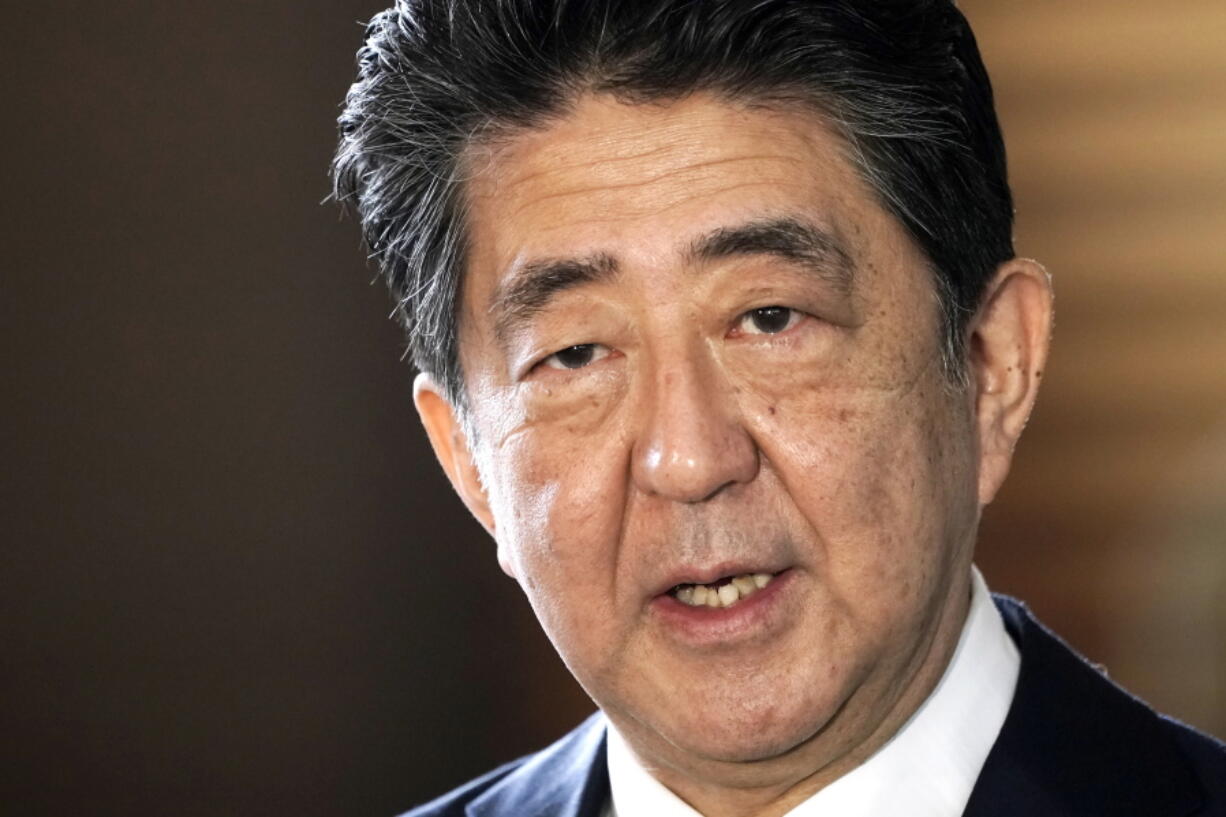 FILE - Japan's outgoing Prime Minister Shinzo Abe speaks to the media as he arrives at the prime minister's office for a cabinet meeting in Tokyo on Sept. 16, 2020. Japan's NHK TV says on Friday, July 7, 2022, former Prime Minister Abe apparently was shot at and collapsed during a campaign speech.