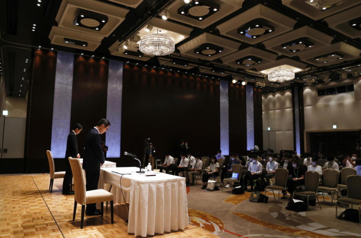 Tomihiro Tanaka, front, head of the Japan branch of South Korea's Unification Church, observes a moment of silence for former Prime Minister Shinzo Abe a a press conference in Tokyo, Monday, July 11, 2022.