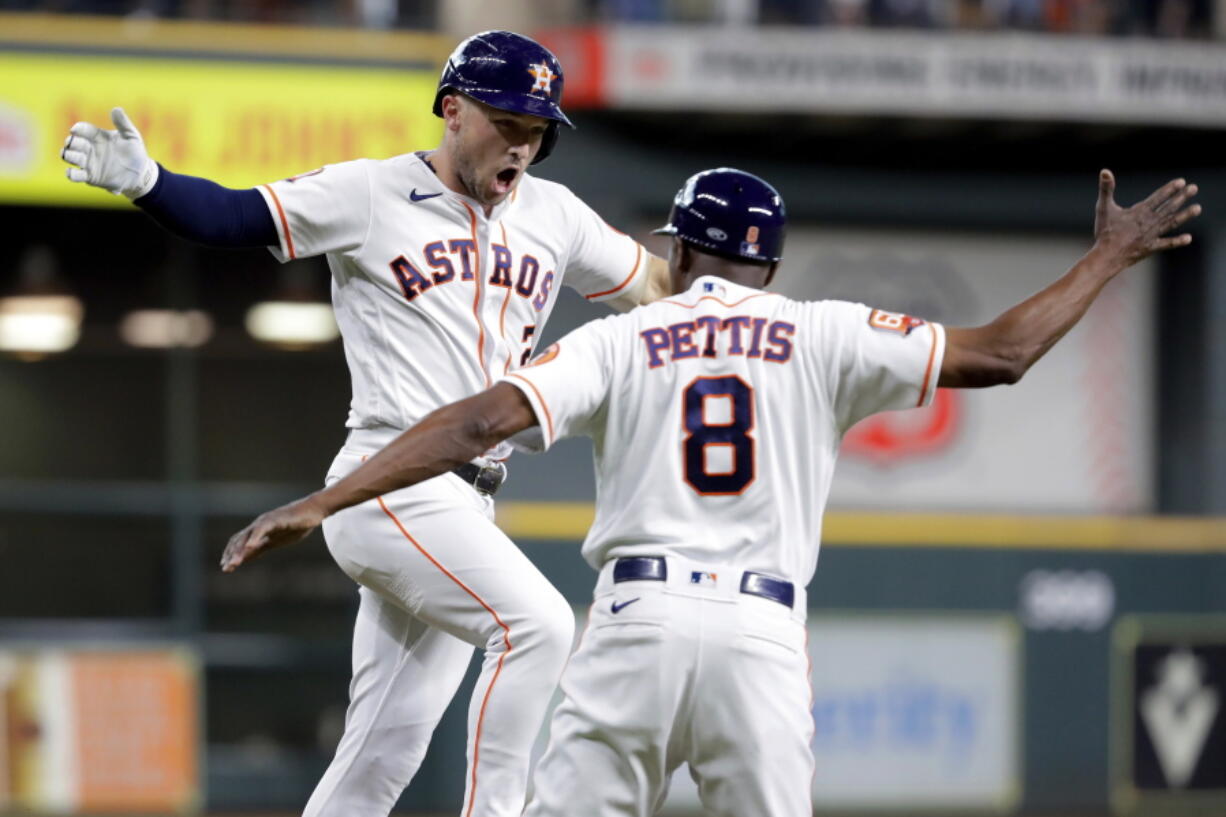 Houston Astros' Alex Bregman, left, celebrates his two-run home run against the Seattle Mariners with third base coach Gary Pettis during the first inning of a baseball game Thursday, July 28, 2022, in Houston.