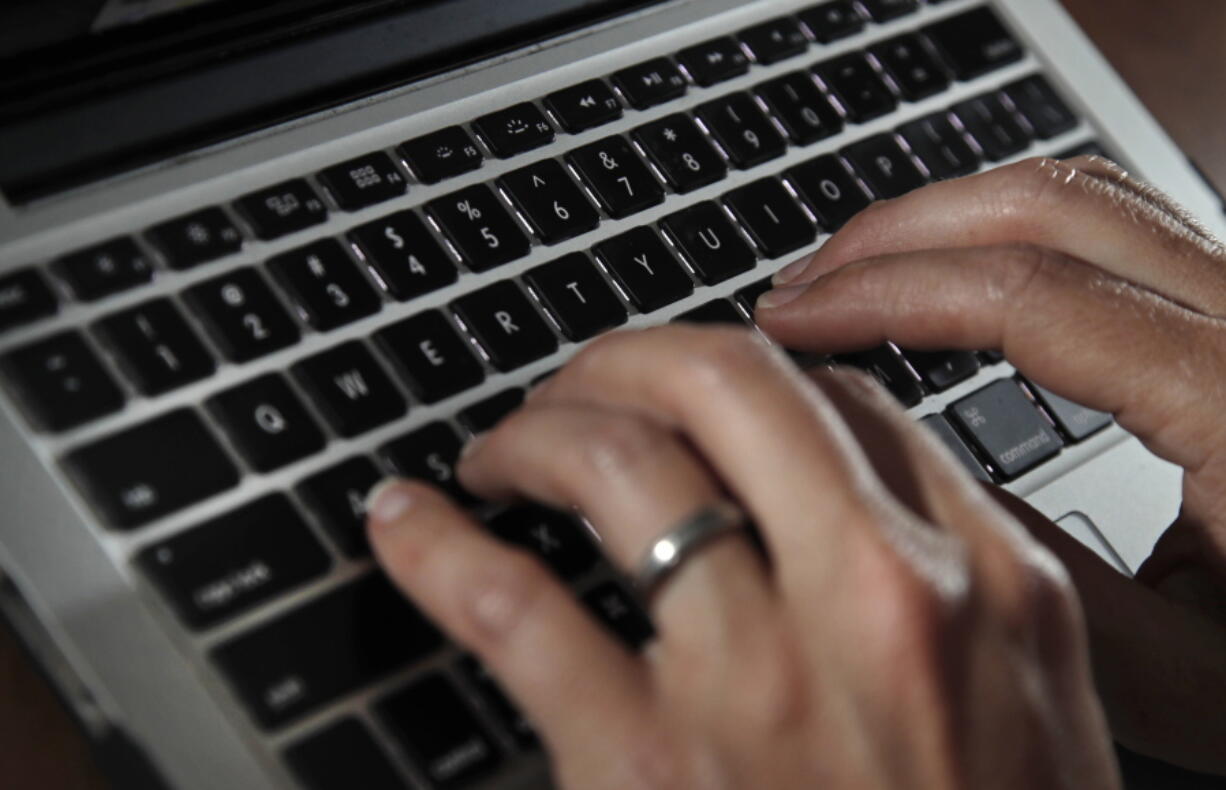 FILE- In this June 19, 2017, file photo, a person types on a laptop keyboard in North Andover, Mass.  The availability of remote work has increased significantly in recent years, giving rise to the ability for telecommuters to buck travel norms. Remote work has blurred the line between business and personal travel, affording workers the flexibility to extend trips to fly on cheaper days.