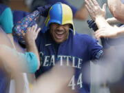 Seattle Mariners' Julio Rodriguez wears a helmet as he is greeted in the dugout after his three-run home run against the Texas Rangers during the seventh inning of a baseball game Wednesday, July 27, 2022, in Seattle. (AP Photo/Ted S.