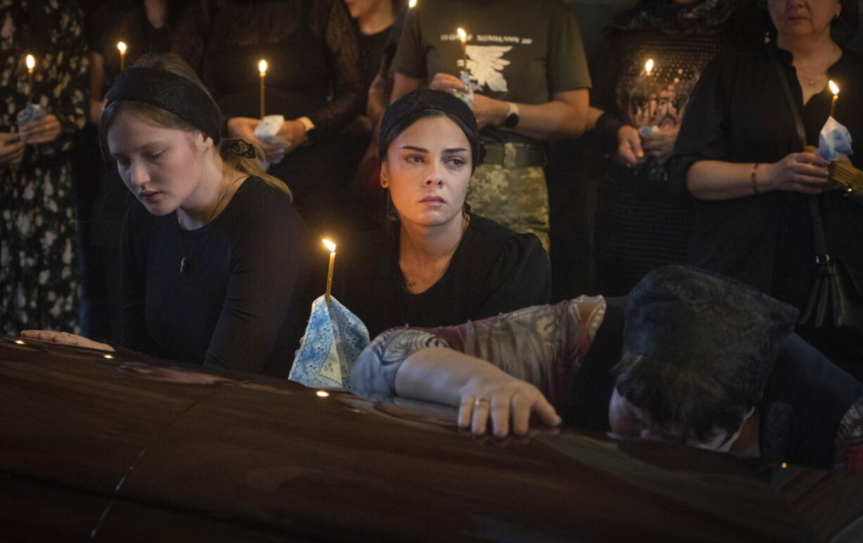 Relatives mourn at the coffin of a soldier, codename Fanat, killed by the Russian troops in a battle during a ceremony at St Michael cathedral in Kyiv, Ukraine, Ukraine, Monday, July 18, 2022.