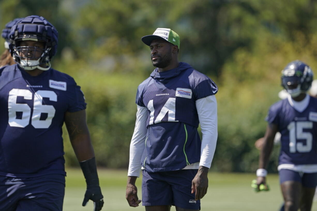 Seattle Seahawks wide receiver DK Metcalf, center, stands on the field during NFL football training camp Thursday, July 28, 2022, in Renton, Wash. (AP Photo/Ted S.