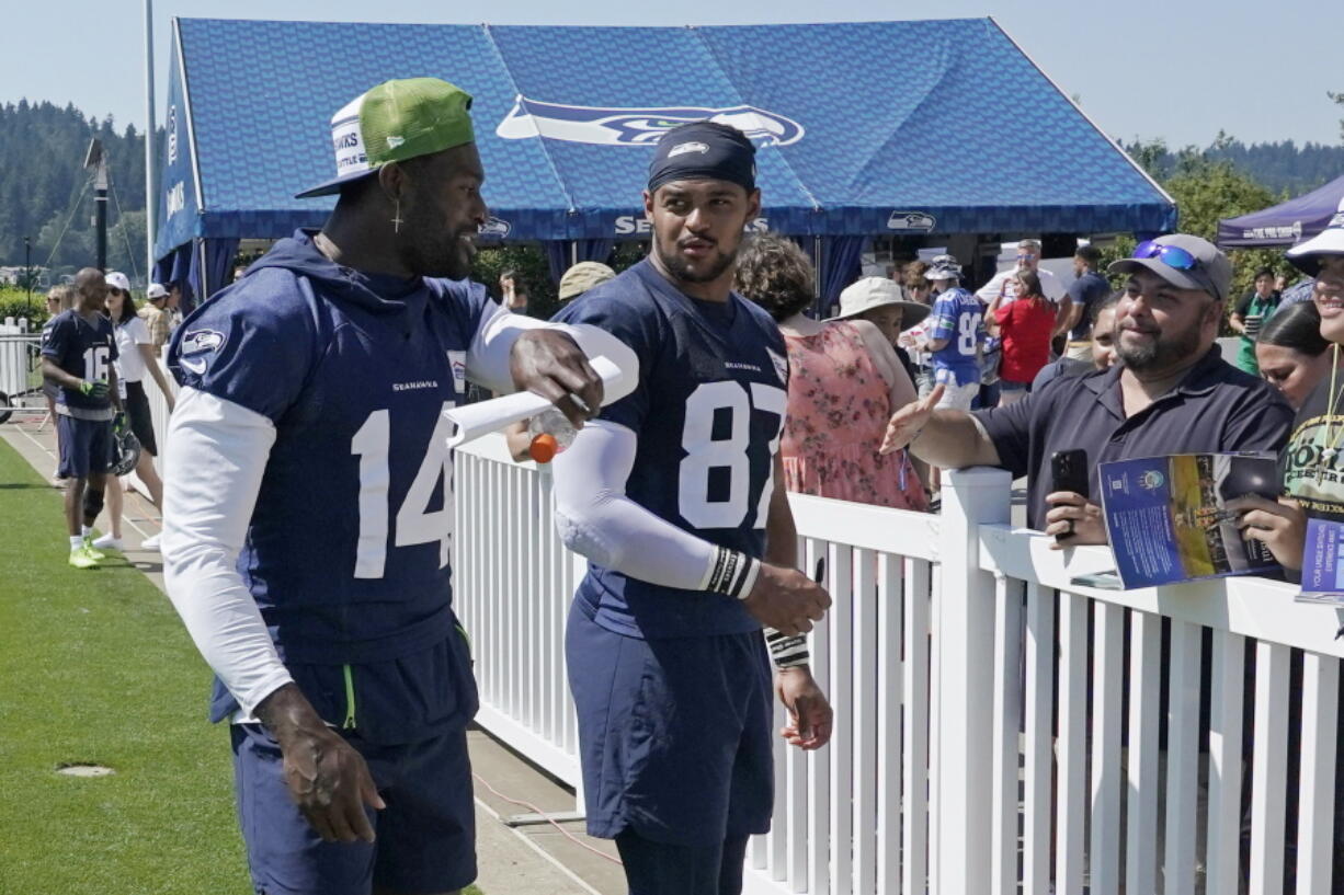 Seattle Seahawks wide receiver DK Metcalf, left, walks with tight end Noah Fant (87) after practice at NFL football training camp Thursday, July 28, 2022, in Renton, Wash. (AP Photo/Ted S.