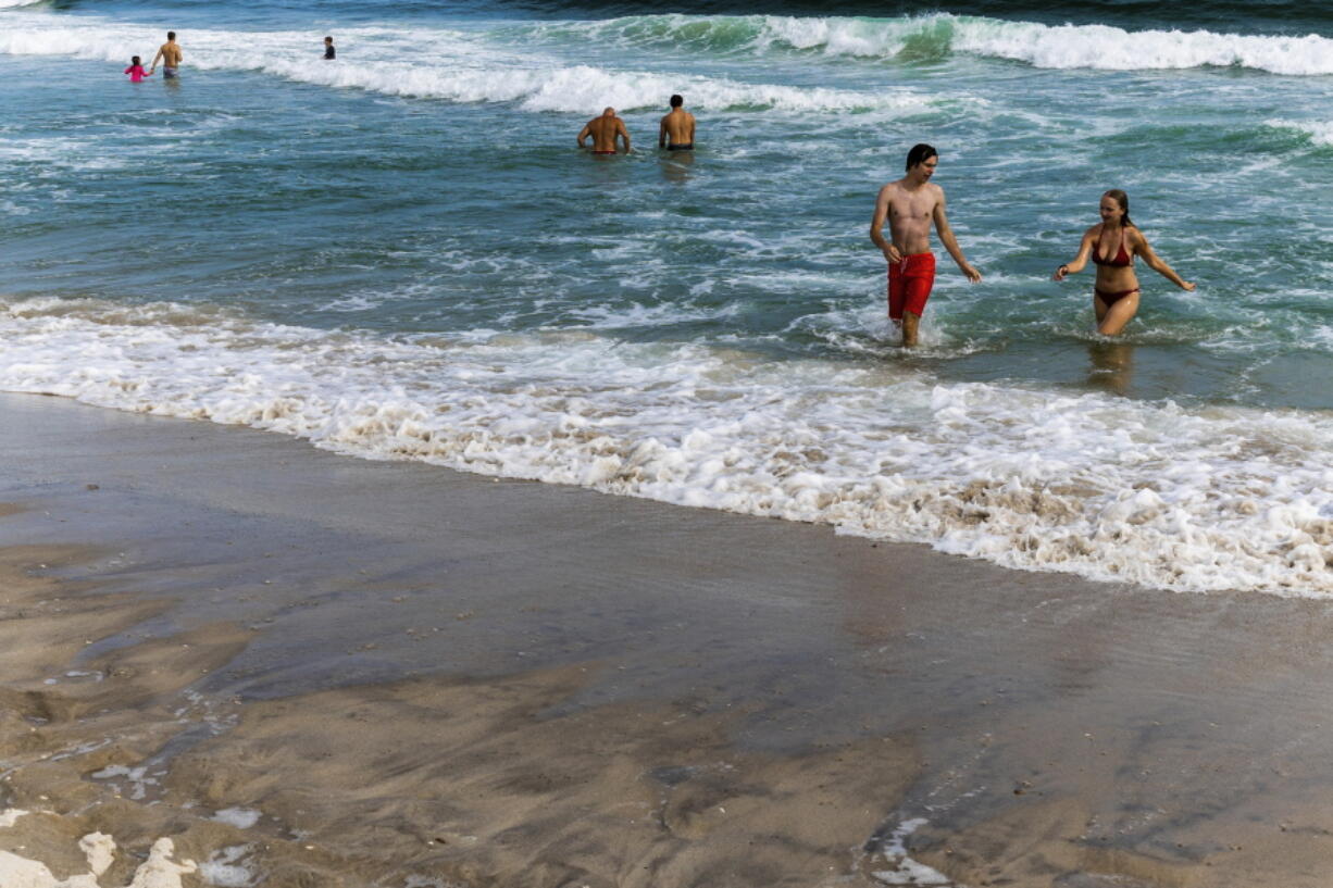 People swim in the ocean at Robert Moses State Park, Wednesday, July 27, 2022, in Babylon, N.Y. Shark sightings have become more common along Long Island's shores this summer and not just the mostly harmless, abundant dogfish. Since June, there have been at least five verified incidents where sharks bit swimmers and surfers.