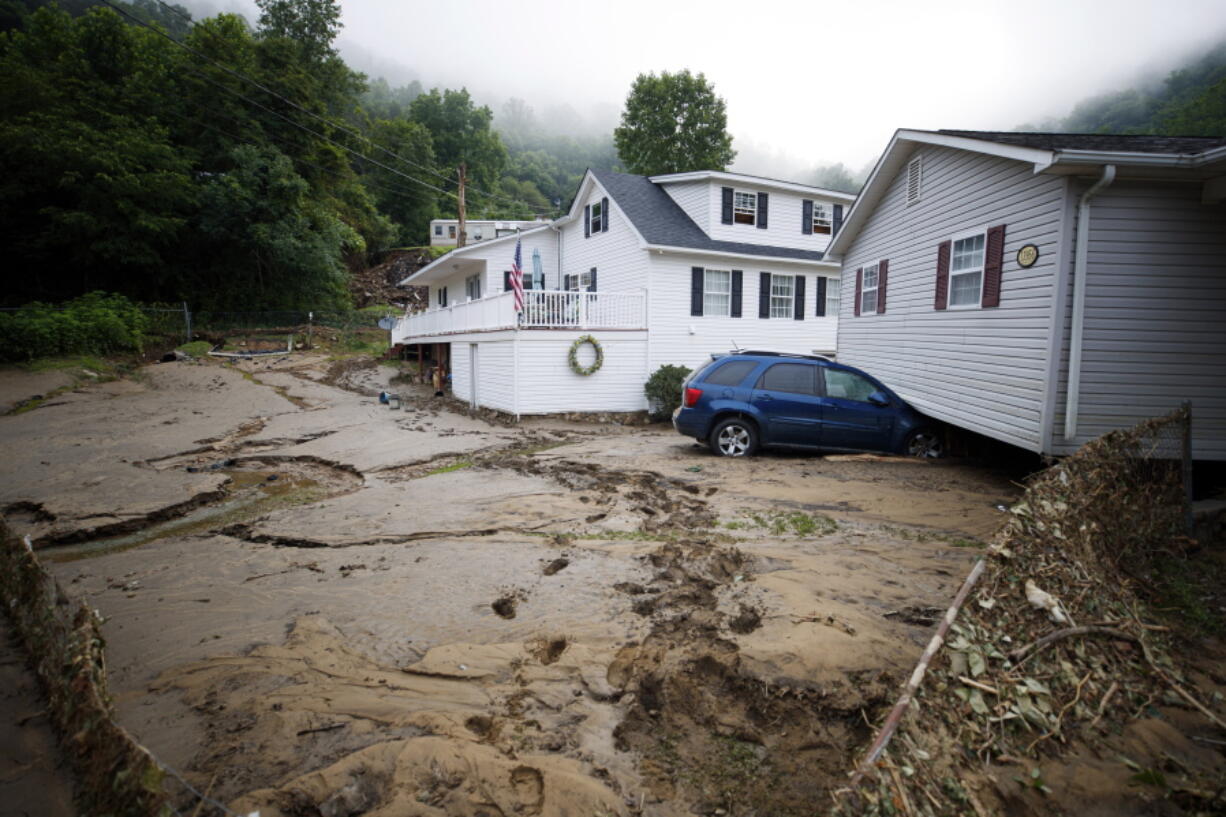 A house that was moved off of its foundation following a flash flood rests on top of a vehicle, Thursday, July 14, 2022 in Whitewood, Va. Virginia Gov. Glenn Youngkin declared a state of emergency to aid in the rescue and recovery efforts from Tuesday's floodwaters.