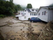 A house that was moved off of its foundation following a flash flood rests on top of a vehicle, Thursday, July 14, 2022 in Whitewood, Va. Virginia Gov. Glenn Youngkin declared a state of emergency to aid in the rescue and recovery efforts from Tuesday's floodwaters.