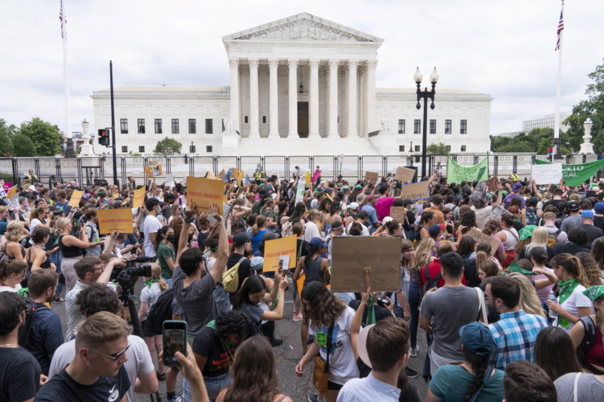 FILE - Protesters gather outside the Supreme Court in Washington, Friday, June 24, 2022. After the U.S. Supreme Court revoked the federal right to an abortion that's been in place for half a century, companies like Amazon, Disney, Apple and JP Morgan pledged to cover travel costs for employees who live in states where the procedure is now illegal so they can terminate pregnancies.