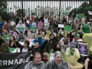 Abortion-rights demonstrators shout slogans after tying green flags to the fence of the White House during a protest to pressure the Biden administration to act and protect abortion rights, in Washington, Saturday, July 9, 2022.