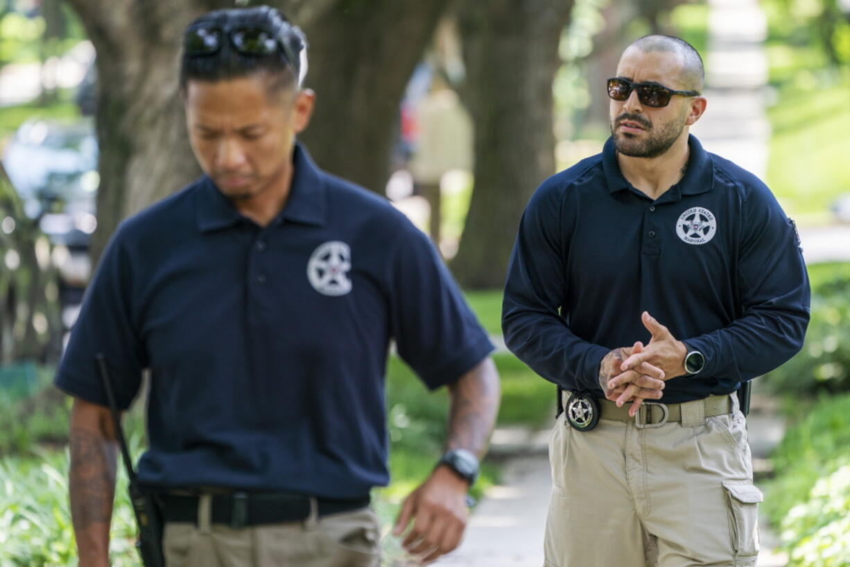 FILE - U.S. Marshals patrol outside the home of Supreme Court Justice Brett Kavanaugh, in Chevy Chase, Md., June 8, 2022. The Marshal of the U.S. Supreme Court has asked Maryland officials to step up the enforcement of laws she says prohibit picketing outside the homes of the justices who live in the state. The request came about a month after a California man was found with a gun, knife and pepper spray near the Maryland home of Kavanaugh after telling police he was planning to kill the justice.