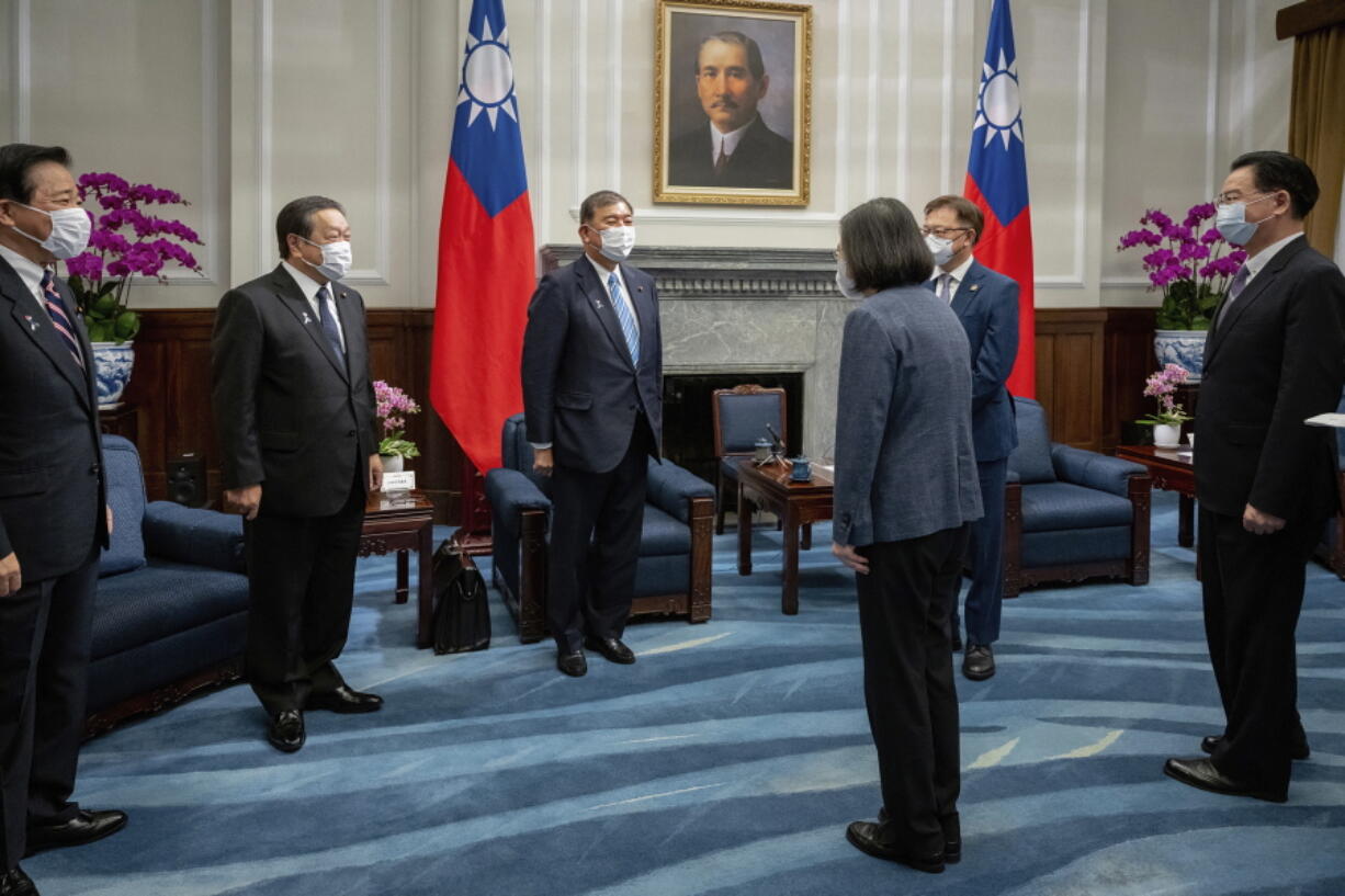 In this photo released by the Taiwan Presidential Office, Taiwan's President Tsai Ing-wen, third right, greets Japanese delegation led by lawmaker and former Defense Minister Shigeru Ishiba, third from left, at the presidential office in Taipei, Taiwan Thursday, July 28, 2022. The group of Japanese lawmakers including two former defense ministers met with Taiwan's president on Thursday in a rare high-level visit to discuss regional security.