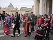 FILE - President of the Metis community, Cassidy Caron, second left, and other delegates arrive to speak to the media in St. Peter's Square after their meeting with Pope Francis at The Vatican, March 28, 2022. Pope Francis' trip to Canada, which begins Sunday July 24, 2022, to apologize for the horrors of church-run Indigenous residential schools marks a radical rethink of the Catholic Church's missionary legacy in the Americas, spurred on by the first American pope and the discovery of hundreds of unmarked graves at the school sites.