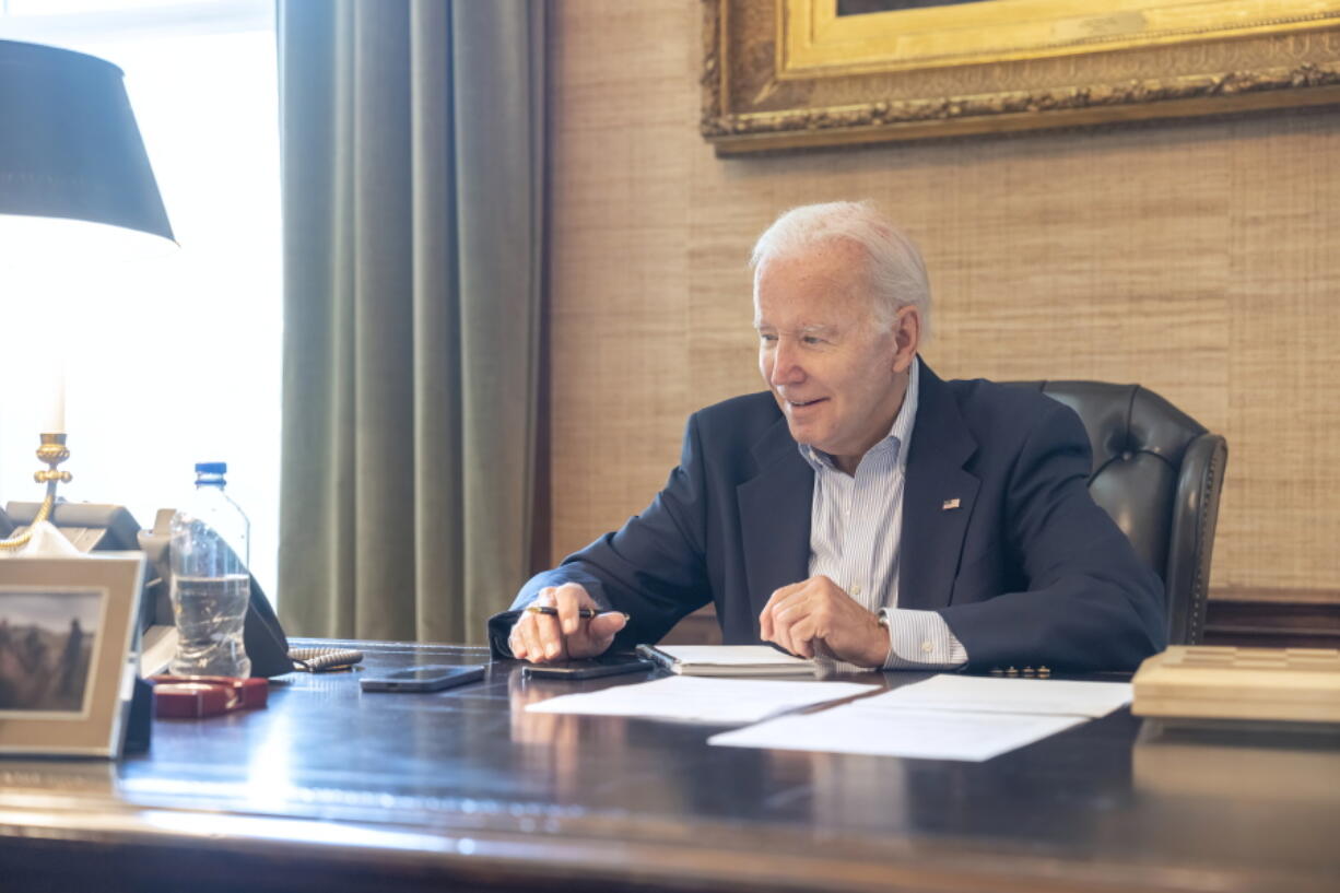 In this image provided by the White House, President Joe Biden speaks with Sen. Bob Casey, D-Pa., on the phone from the Treaty Room in the residence of the White House Thursday, July 21, 2022, in Washington. Biden says he's "doing great" after testing positive for COVID-19. The White House said Biden is experiencing "very mild symptoms," including a stuffy nose, fatigue and cough. He's taking Paxlovid, an antiviral drug designed to reduce the severity of the disease.