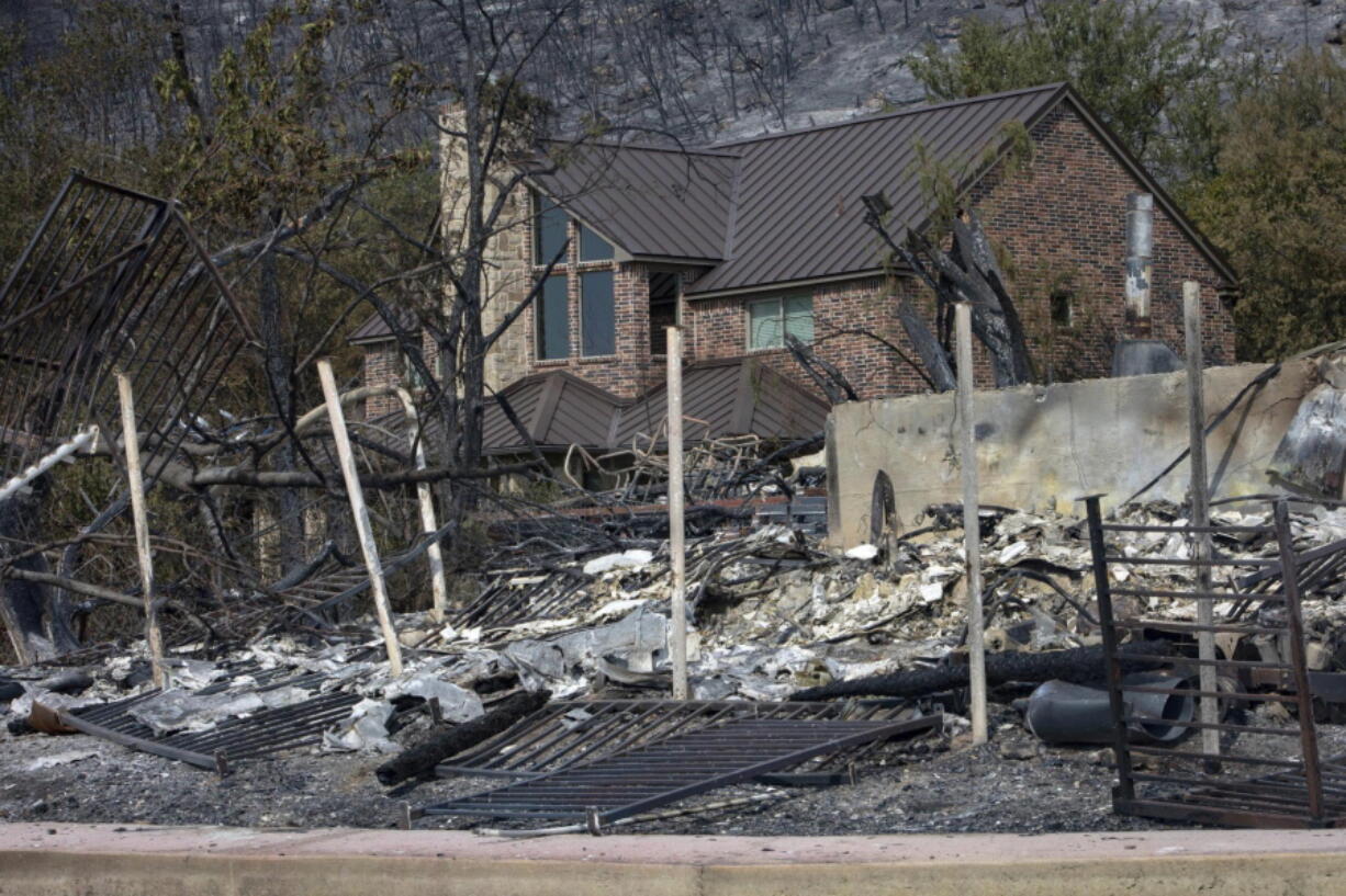 An intact house just behind the remains of a home on Possum Kingdom Lake in Graford, Texas, on Wednesday.