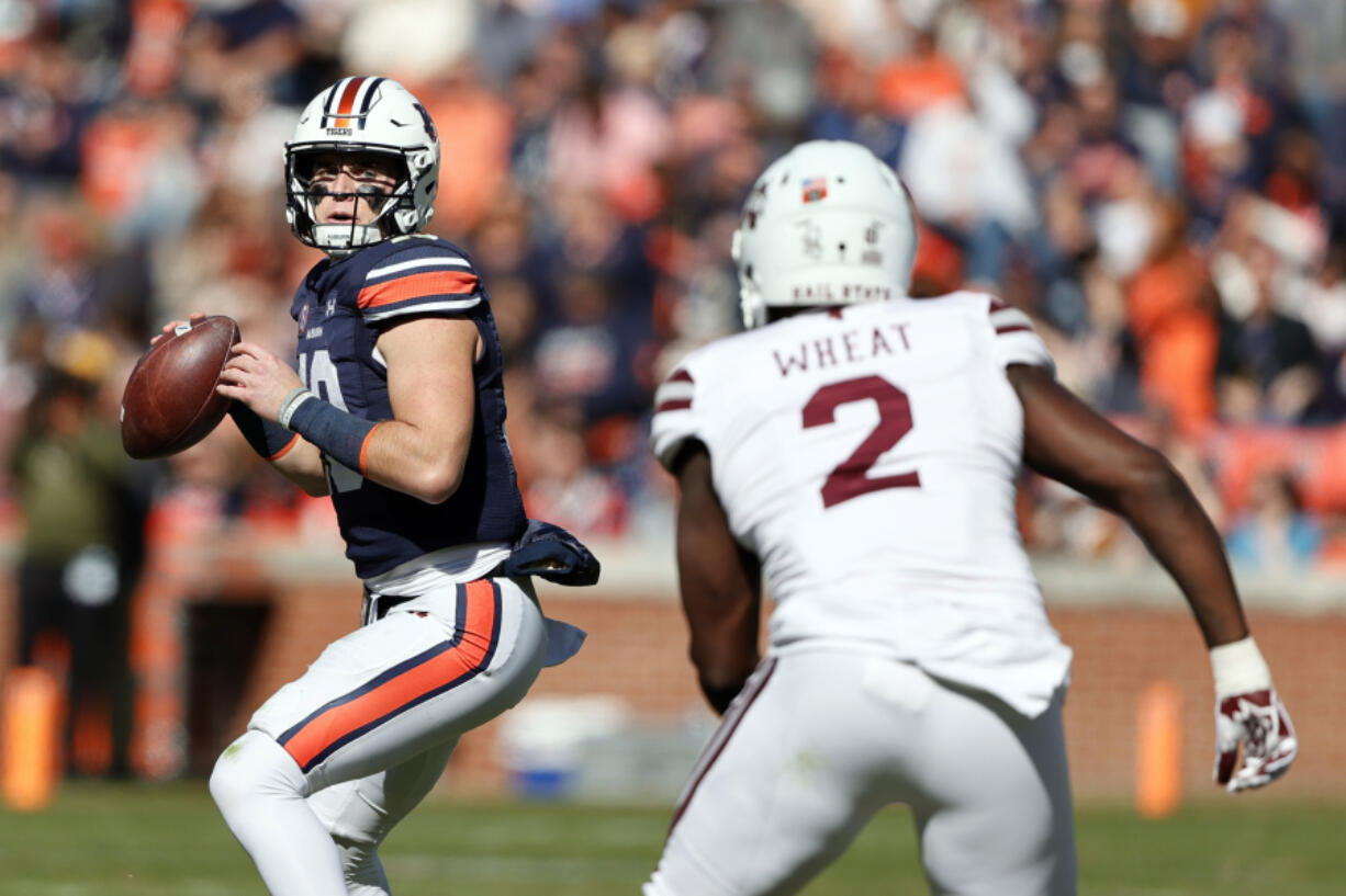 Auburn quarterback Bo Nix (10) throws a pass as Mississippi State linebacker Tyrus Wheat (2) brings pressure during the first half of an NCAA college football game Saturday, Nov. 13, 2021, in Auburn, Ala.