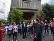 Parishioners who refuse to abandon their locked-up Our Lady of Mount Virgin Catholic Church converse after a service without Mass held on the sidewalk July 17 in Seattle's Mount Baker neighborhood.