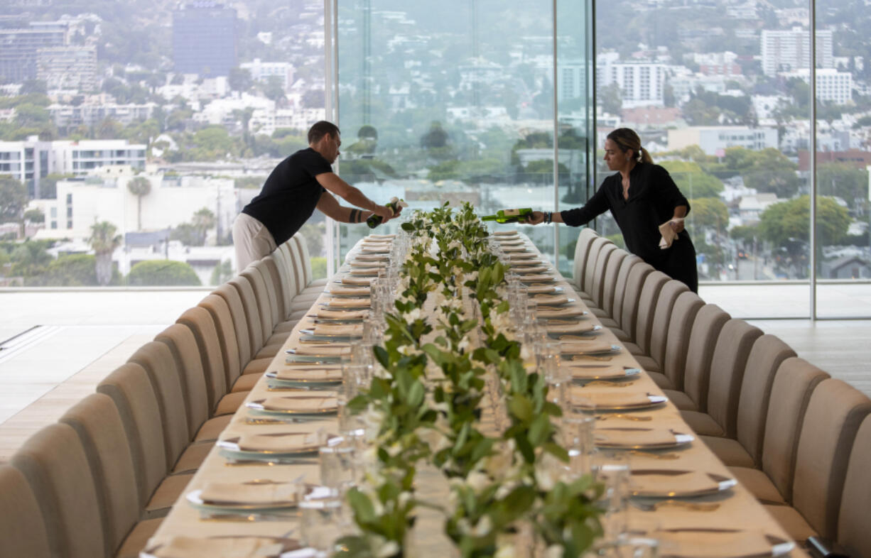 Wine is poured as staff members prepare a five-course dinner during a VIP event at 8899 Beverly, one of the most exclusive condo residences ever built, on June 15, 2022, in West Hollywood, California.