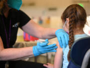 A nurse administers a pediatric dose of the COVID-19 vaccine to a girl at a L.A. Care Health Plan vaccination clinic at Los Angeles Mission College in the Sylmar neighborhood in Los Angeles, California, Jan. 19, 2022.