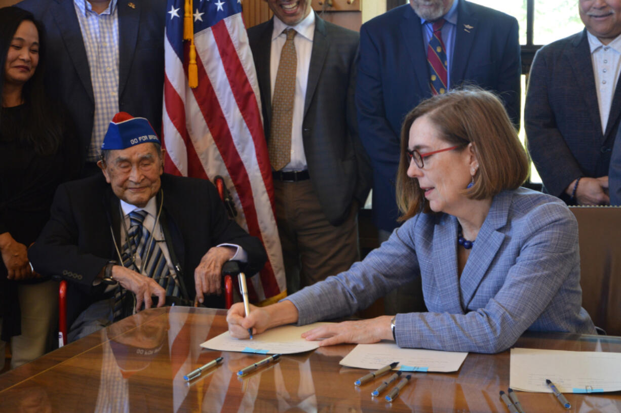 Yoshiro "Yosh" Tokiwa of Vancouver, left, watches as Oregon Gov.