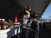 Sam Hernandez of Hockinson helps his son, Benjamin, with the syrup at the Clark County Fair on Friday.
