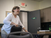 Dairn Woodman smiles as she helps set up a conference room for an art class Monday at the Luepke Center.