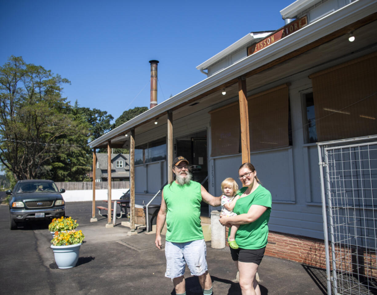 Eric Johnson, left, and Jenell Anderson, right, holding 1-year-old daughter Nora Einarson, own the Heisson Store along with Gionni Johnson, Eric's wife and Anderson's mother.