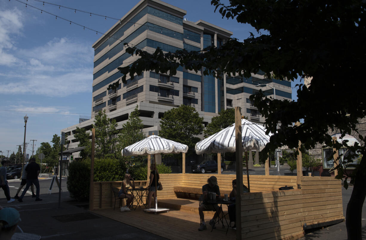 Visitors to Compass Coffee in downtown Vancouver enjoy their drinks in a parklet on Monday morning. The city has extended the parklet program, but will begin charging business owners.