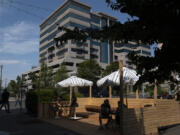 Visitors to Compass Coffee in downtown Vancouver enjoy their drinks in a parklet on Monday morning. The city has extended the parklet program, but will begin charging business owners.