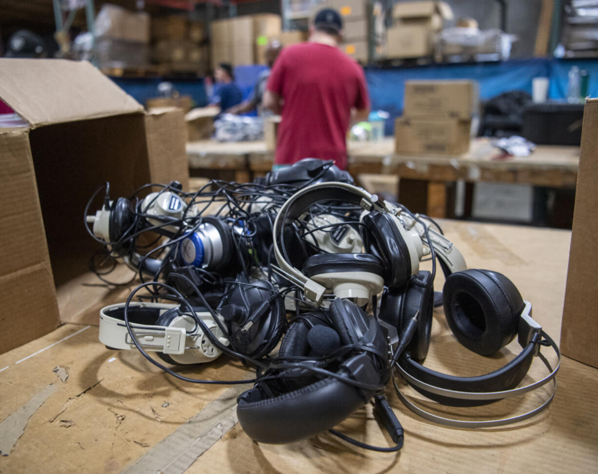 Headphones sit on a table before they are sorted and recycled. They will be disassembled and sorted by material before recycling.