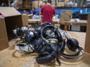 Headphones sit on a table before they are sorted and recycled. They will be disassembled and sorted by material before recycling.