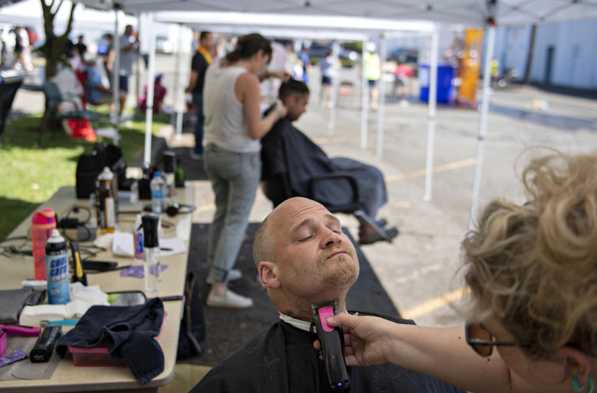 Vancouver resident John Beakley gets a free haircut and beard trim from Briana Schwarz of Great Clips during the Open House Ministries annual block party in 2022. The event included a wellness clinic, informational booths and a preventive pet care clinic. The party returned this year following a two-year hiatus caused by the COVID-19 pandemic.