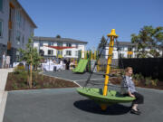 Vancouver Mayor Anne McEnerny-Ogle tests out some of the new playground equipment at Columbia Heights affordable housing complex during its grand opening on Wednesday afternoon.