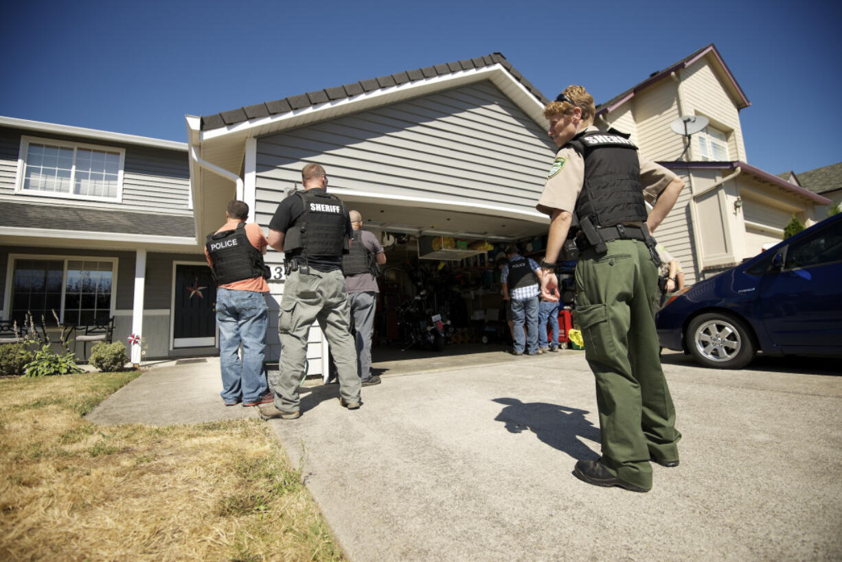 A deputy sheriff assists Clark-Vancouver Drug Task Force members during a drug bust operation in Vancouver.