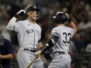 New York Yankees' Aaron Judge celebrates with Tim Locastro after hitting a solo home run on a pitch from Seattle Mariners' Ryan Borucki during the ninth inning of a baseball game, Monday, Aug. 8, 2022, in Seattle.