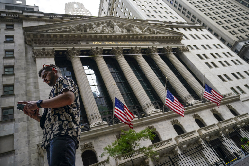 FILE - Pedestrians walk past the New York Stock Exchange, on July 8, 2022, in New York.  Stocks are opening lower on Wall Street Wednesday, Aug. 17,  as traders absorb some discouraging news about how much Americans are spending.