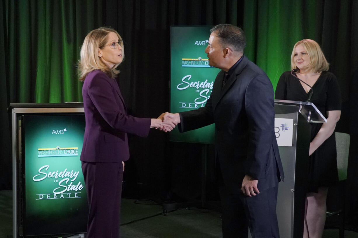 Washington Secretary of State Steve Hobbs, second from right, a Democrat, and Pierce County Auditor Julie Anderson, left, running as a nonpartisan, shake hands after taking part in a debate, Wednesday, Aug. 17, 2022, in Olympia, Wash., as moderator Melissa Santos, right, of Axios Local, looks on. Hobbs and Anderson are seeking to fill the remaining two years of the term of Republican Secretary of State Kim Wyman, who left to take a key election security job in the Biden administration. (AP Photo/Ted S.