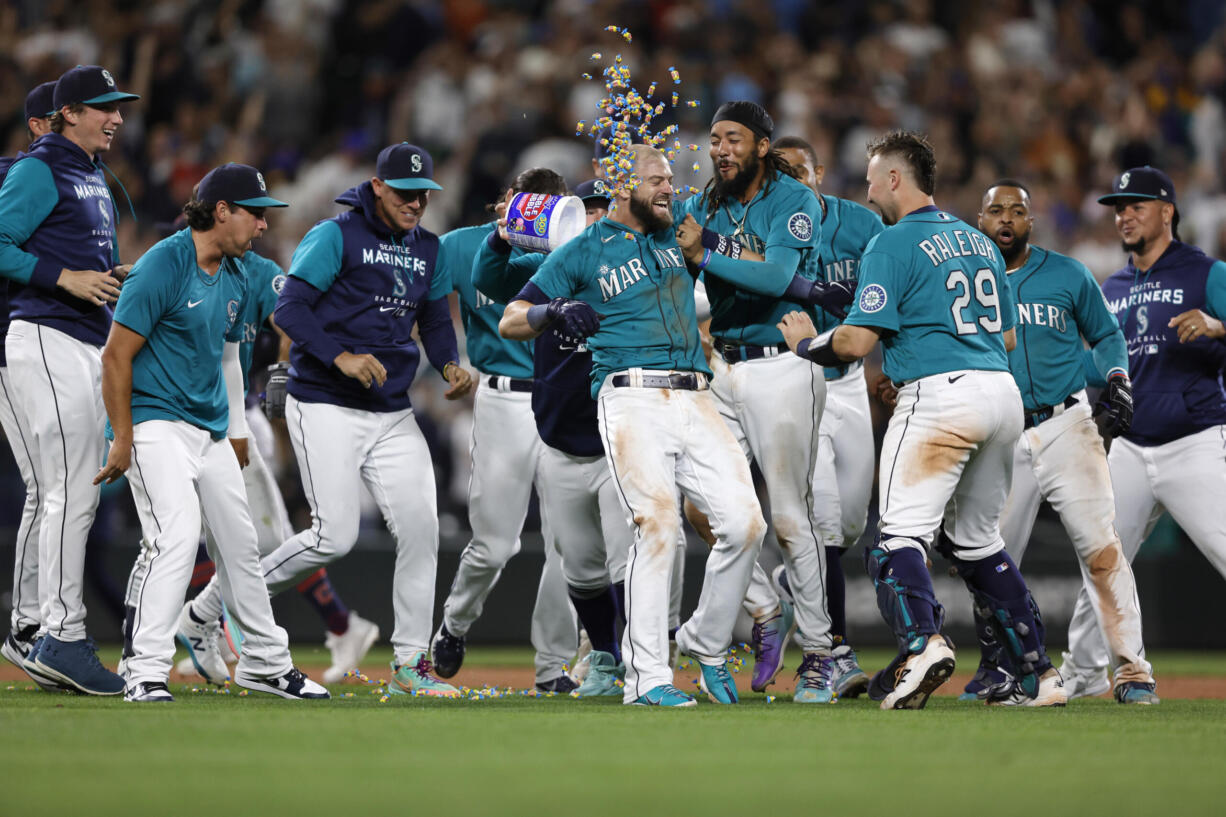 Seattle Mariners' Mitch Haniger celebrates his RBI single to win 3-2 against the Cleveland Guardians during the 11th inning of a baseball game, Friday, Aug. 26, 2022, in Seattle.