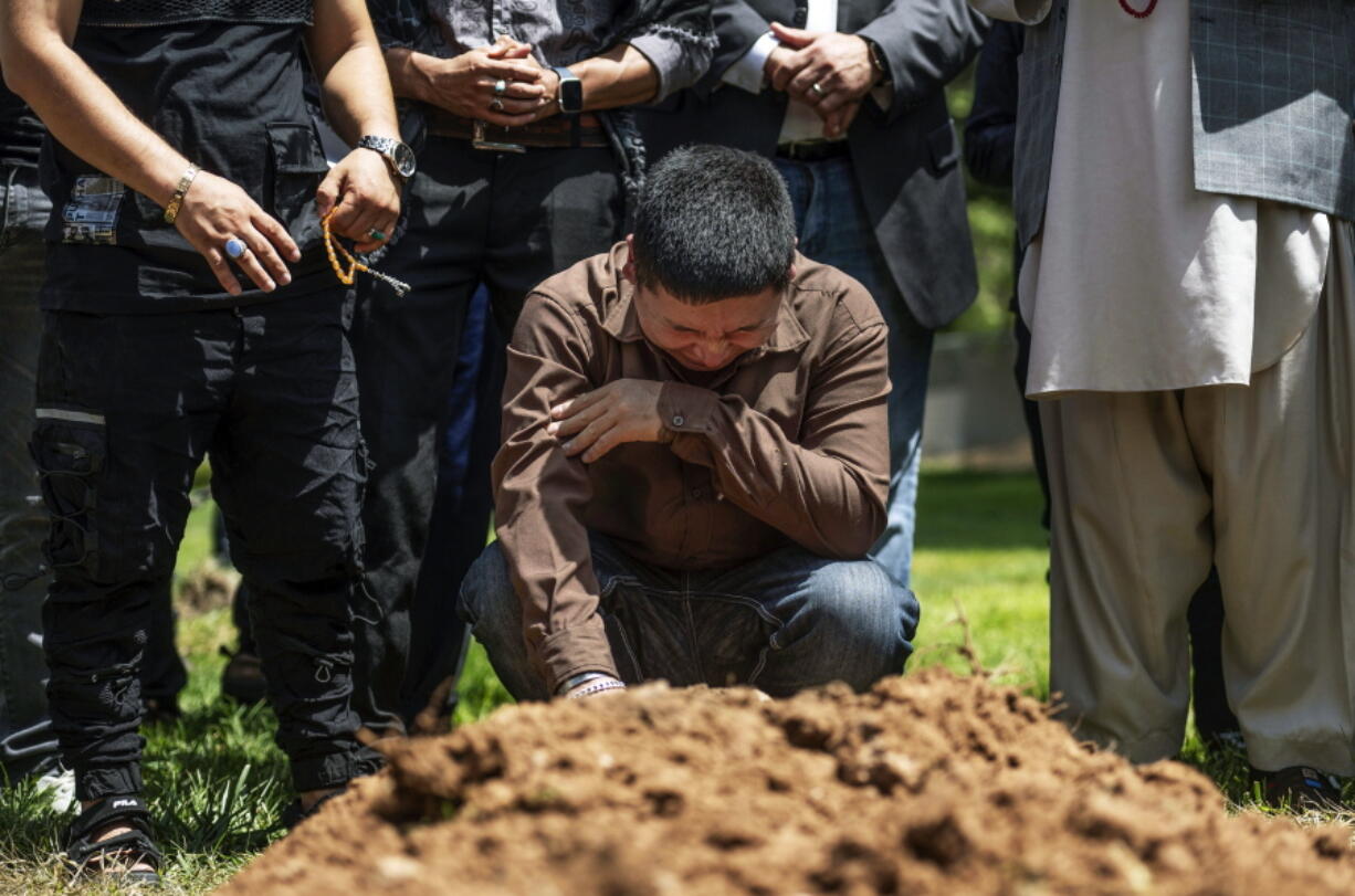 Altaf Hussain cries over the grave of his brother Aftab Hussein at Fairview Memorial Park in Albuquerque, N.M., on Friday, Aug. 5, 2022. A funeral service was held for Aftab Hussein, 41, and Muhammad Afzaal Hussain, 27, at the Islamic Center of New Mexico on Friday. Both Muslim men were shot and killed near their homes only six days apart. Law enforcement believes one suspect could be responsible for killing three Muslim men in the past nine months.