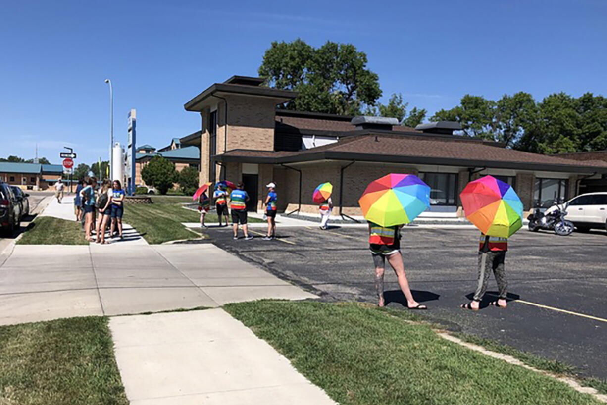 Volunteer escorts and others stand outside the Red River Women's Clinic in Moorhead, Minn., Wednesday, Aug. 10, 2022. The clinic has operated since 1998 in Fargo, where it was North Dakota's only abortion clinic, but now faces likely shutdown on a trigger law banning abortion due to take effect in late August. Wednesday was its first day of operation just a couple of miles away at the new Moorhead location.