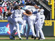 Seattle Mariners players celebrate with a group dance in center field after defeating the Los Angeles Angels in the first game of a baseball doubleheader, Saturday, Aug. 6, 2022, in Seattle.