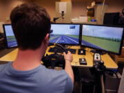 Tate Ellwood-Mielewski test drives on a simulator at the University of Michigan, Friday, April 29, 2022, in Ann Arbor, Mich. Michigan researchers plan to study how well those with autism spectrum disorder detect road hazards and assist the young motorists in sharpening their driving skills. The upcoming effort marks the second phase of a project that is funded by Ford Motor Co. and teams the Ann Arbor university with a local driving school.