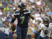 Seattle Seahawks quarterback Geno Smith (7) drops to pass as Chicago Bears' Kyler Gordon (6) closes in during the first half of a preseason NFL football game, Thursday, Aug. 18, 2022, in Seattle.