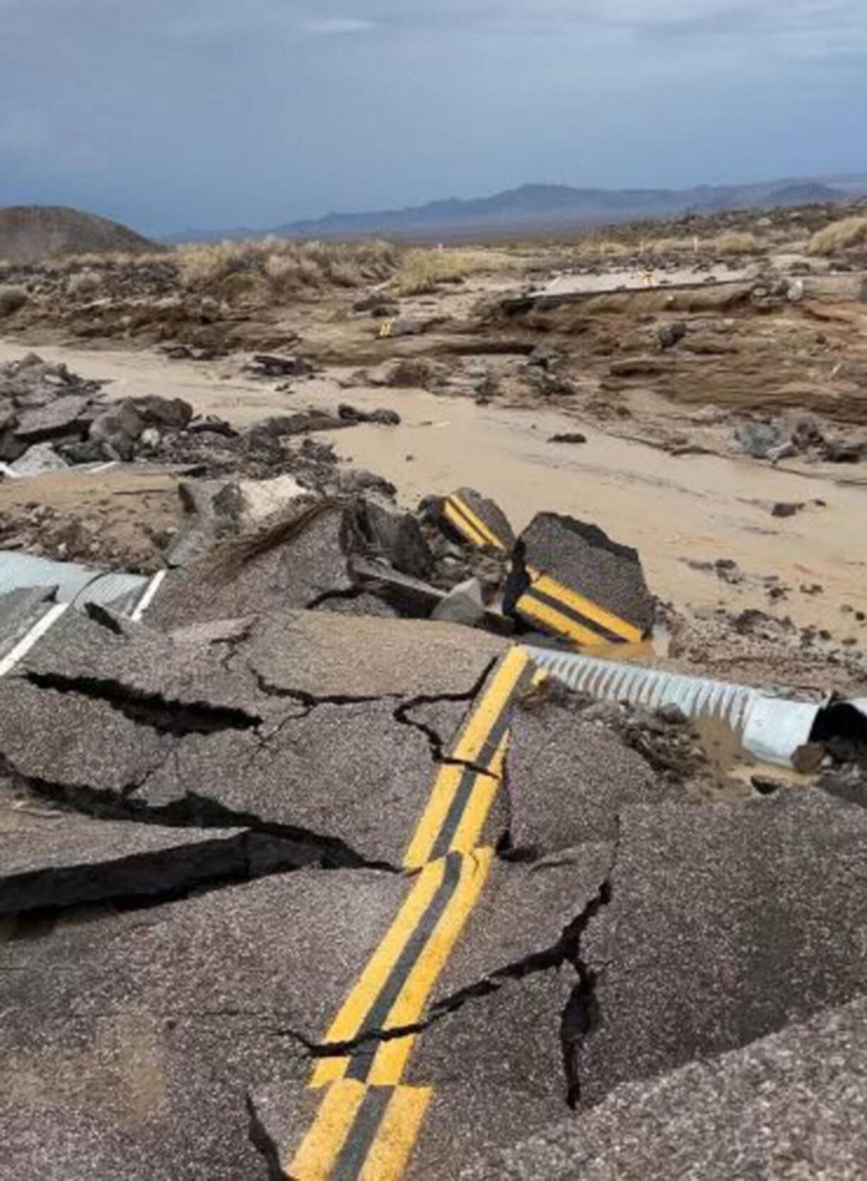 In this photo released by the National Park Service, is the damaged intersection of Kelbacker Road and Mojave Road in the Mojave National Preserve, Calif., Sunday, July 31, 2022. Roads in and out of Death Valley National Park were closed after lanes mud and debris inundated lanes during weekend flash floods in eastern California, western Nevada and northern Arizona. Storm cells dumped localized heavy rain across the region, prompting closures of highways and campgrounds.